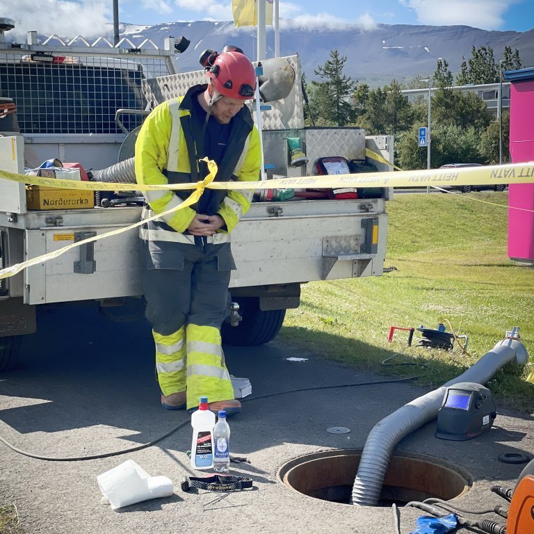 Brunnafjarlæging krefst þess að vatn sé tekið af ákveðnum svæðum. Hér er búið er að loka fyrir vatn svo framkvæmd geti átt sér stað. Ofan í jörðinni er starfsmaður (sem ekki sést í) sem sér um að loka fyrir vatnið á svæðinu. Ávallt er starfsmaður ofanjarðar sem tryggir öryggi þess sem lokar fyrir vatnið.